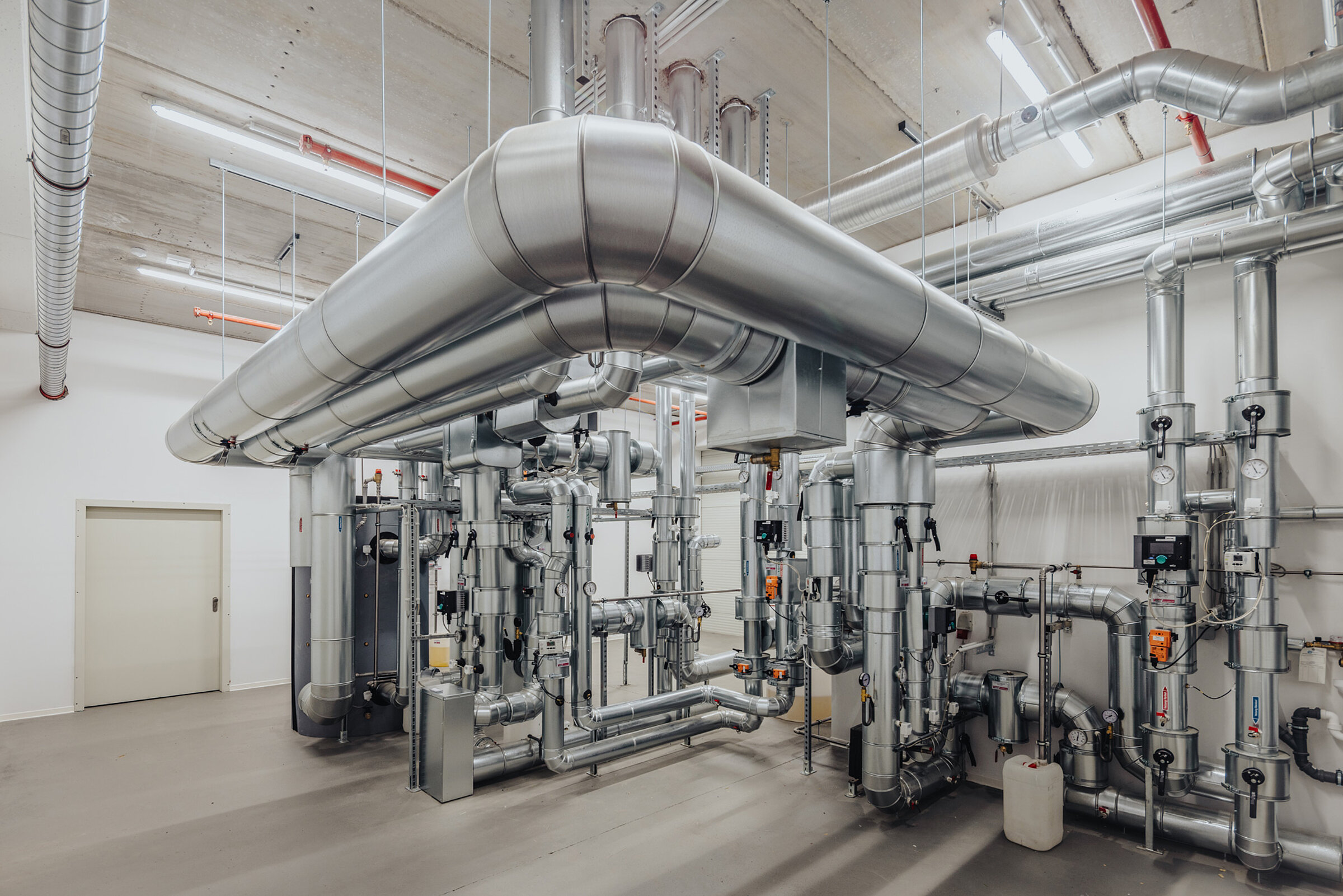 Room with metal pipes and technical equipment used for building services.